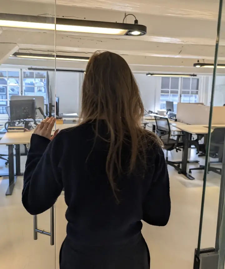 Open-plan office with sit-stand desks behind a glass door, franchise marketing agency Herengracht 280 Amsterdam