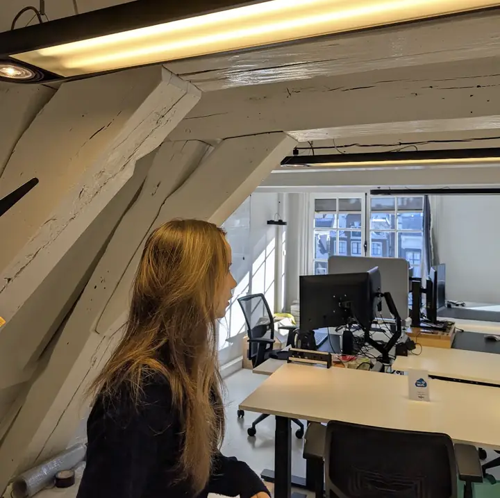 Attic office with white wooden beams and desks, workspace of the franchise marketing team in Amsterdam