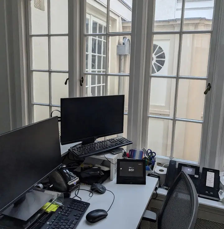 Workstation with two monitors by a window of the canal house, where campaigns for franchise brands are created